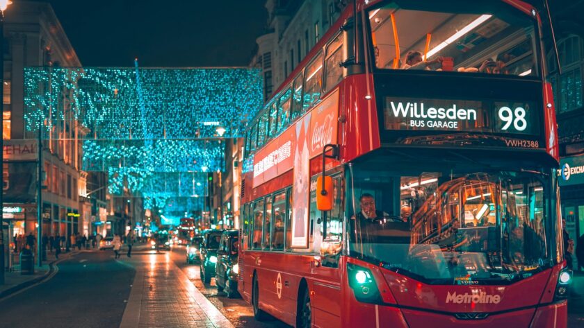 a red double decker bus driving down a street